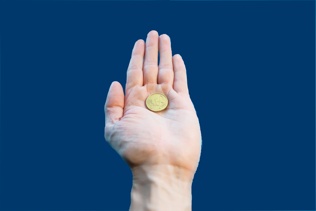A man holds one coin in his palm, close-up. Fifty cents euro in hand, POV. Bankruptcy, poverty, falling income, low cost. Blue background